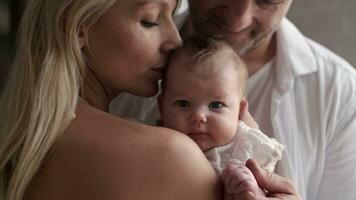 man en vrouw kus hun pasgeboren baby. detailopname. video