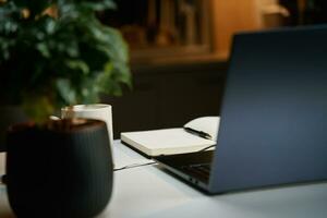 Workplace at home office. Laptop on table at night living room photo