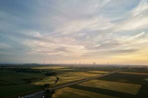 la carretera con coche tráfico y molino turbinas a puesta de sol foto