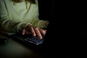 anónimo mujer trabajando en ordenador portátil a noche foto