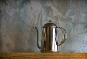 Silver coffee pots on wood shelf for home interior. photo