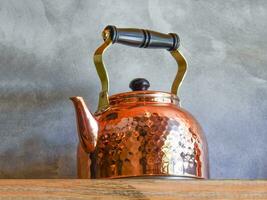 Old fashioned Copper Kettle on shelf. photo