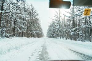 Beautiful snow road forest view during car driving in winter season. Winter travel, Road trip, Adventure, Exploring and Vacation concepts photo