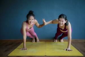 dos asiático mujer haciendo yoga con felicidad foto