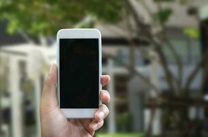 Man's hand shows mobile smartphone in vertical position photo