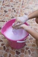 Hand washing clothes in the basin. photo