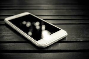 inteligente teléfono con blanco pantalla acostado en mesa foto