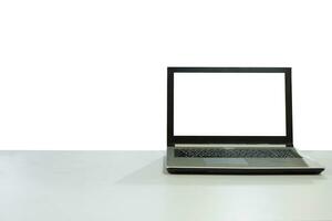 Blank display laptop on white desk with copy space background photo