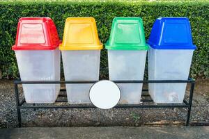 Red, yellow, green, blue plastic with cap recycle bins in park photo