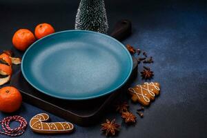 Beautiful festive Christmas composition of an empty plate, tangerine and gingerbreads photo