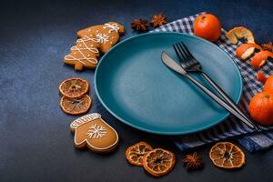 Beautiful festive Christmas composition of an empty plate, tangerine and gingerbreads photo