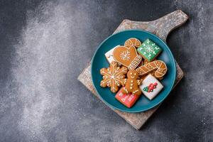 hermosa delicioso dulce invierno Navidad pan de jengibre galletas en un gris texturizado antecedentes foto