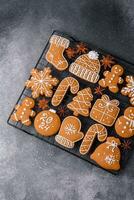 hermosa delicioso dulce invierno Navidad pan de jengibre galletas en un gris texturizado antecedentes foto