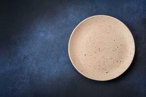 Round empty colored ceramic plate on concrete texture background photo