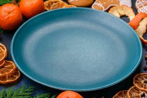 Beautiful festive Christmas composition of an empty plate, tangerine and gingerbreads photo