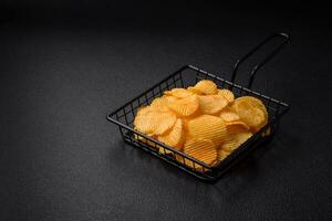 Crispy potato chips with salt, spices and herbs photo