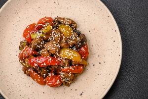 Warm salad with veal, tomatoes, peppers, zucchini, sesame, salt, spices and herbs photo