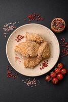 Delicious fresh crispy chicken nuggets on a dark concrete background photo