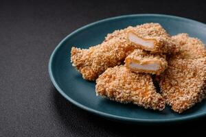 Delicious fresh crispy chicken nuggets on a dark concrete background photo