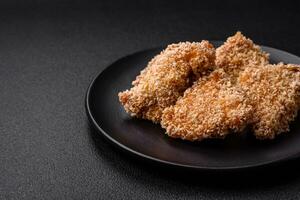 Delicious fresh crispy chicken nuggets on a dark concrete background photo