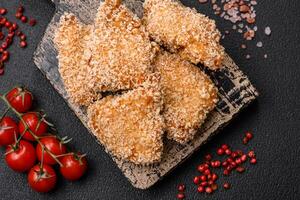 Delicious fresh crispy chicken nuggets on a dark concrete background photo