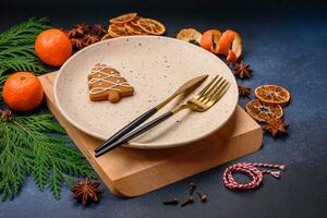 Beautiful festive Christmas composition of an empty plate, tangerine and gingerbreads photo