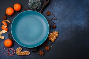 Beautiful festive Christmas composition of an empty plate, tangerine and gingerbreads photo