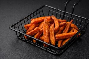 Delicious crispy sweet potato fries with salt, spices and herbs photo