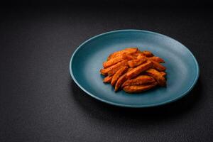 Delicious crispy sweet potato fries with salt, spices and herbs photo