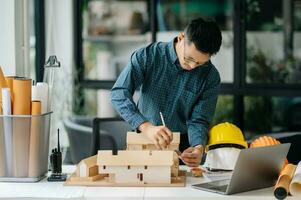 Male architect hands making model house. Man architect working in the office. photo