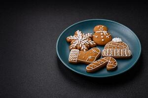 Beautiful Christmas gingerbread cookies of different colors on a ceramic plate photo