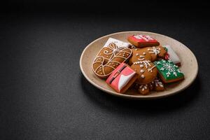 hermosa Navidad pan de jengibre galletas de diferente colores en un cerámico plato foto