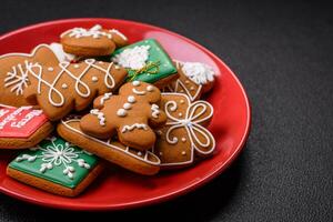 Beautiful Christmas gingerbread cookies of different colors on a ceramic plate photo