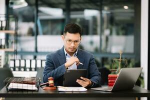 Man lawyer working and gavel, tablet, laptop in front, Advice justice and law concept. photo