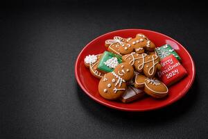 hermosa Navidad pan de jengibre galletas de diferente colores en un cerámico plato foto