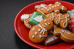 hermosa Navidad pan de jengibre galletas de diferente colores en un cerámico plato foto