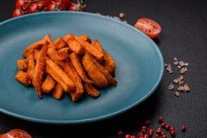 Delicious crispy sweet potato fries with salt, spices and herbs photo