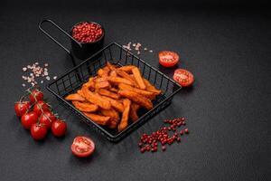 Delicious crispy sweet potato fries with salt, spices and herbs photo