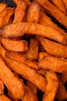 Delicious crispy sweet potato fries with salt, spices and herbs photo