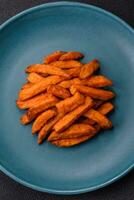 Delicious crispy sweet potato fries with salt, spices and herbs photo