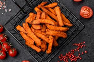 Delicious crispy sweet potato fries with salt, spices and herbs photo