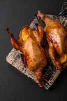 Roasted quail, partridge or pigeon stuffed with orange with spices and herbs photo