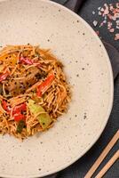 delicioso udon tallarines con carne o mariscos, verduras, sal y especias foto