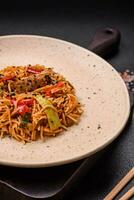 delicioso udon tallarines con carne o mariscos, verduras, sal y especias foto