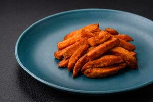 Delicious crispy sweet potato fries with salt, spices and herbs photo