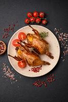 Roasted quail, partridge or pigeon stuffed with orange with spices and herbs photo