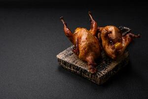 Roasted quail, partridge or pigeon stuffed with orange with spices and herbs photo