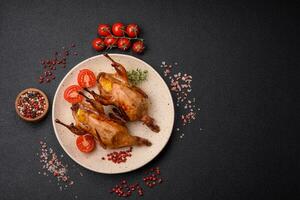Roasted quail, partridge or pigeon stuffed with orange with spices and herbs photo