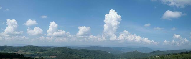 montaña ver y azul cielo con blanco nubes foto