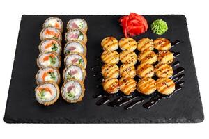 Sushi conjunto con jengibre y wasabi en pizarra plato foto